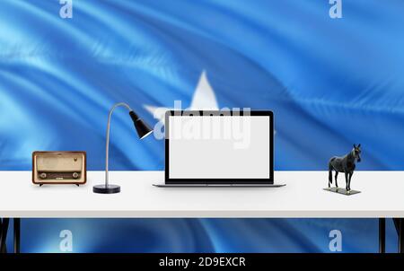 Somalia Nationalflagge Hintergrund mit Arbeitsbereich, Desktop-Computer und Office-Zubehör auf weißem modernen Tisch. Stockfoto