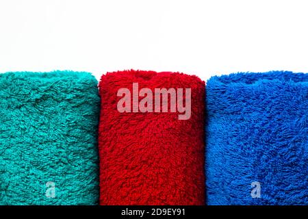 Handtücher in drei Farben auf weißem Hintergrund. Rot grün und blau. Stockfoto