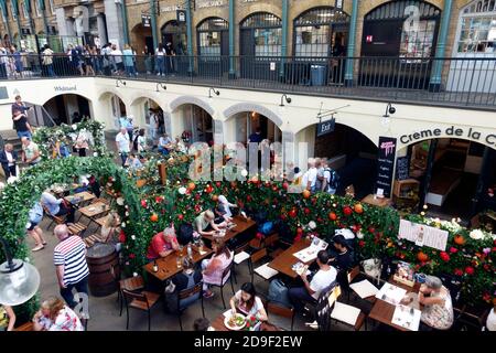 Menschen essen im Freien auf dem Markt Covent Garden Market auf der Covent Garden Piazza, London, England Stockfoto