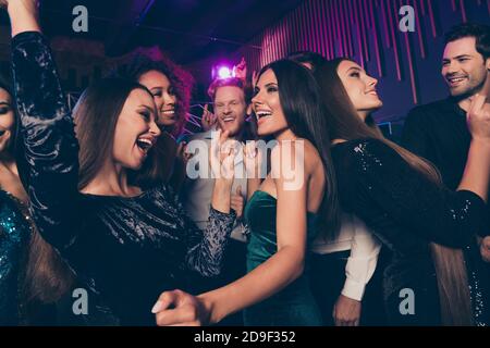 Foto von jungen Leuten, die im Nachtclub mit Neon tanzen Lichter chillen zusammen Lachen genießen Musik feiern Neujahr Weihnachten Stockfoto