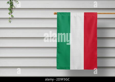 Ungarn nationale kleine Flagge hängt von einem Pfostenzaun entlang der Holzmauer in einer ländlichen Stadt. Konzept des Unabhängigkeitstages. Stockfoto