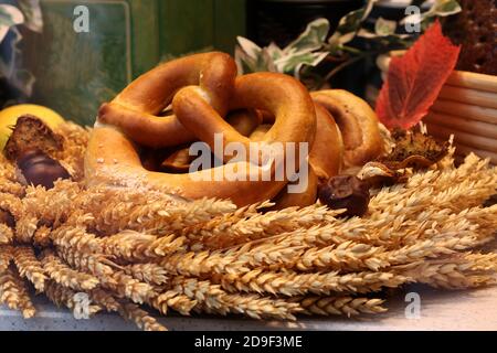 Nahaufnahme von Brezeln und Weizenohren hinter dem Fenster einer Bäckerei. Stockfoto