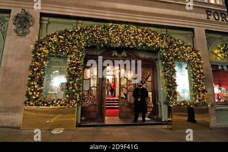 London, Großbritannien. November 2020. Der Seiteneingang des Ladens ist von weihnachtlichen Blättern und Lichtern umgeben.Piccadilly Kaufhaus Fortnum & Mason ist weltweit bekannt und bekannt als "The Queen's Grocer", nachdem er eine TV-Dokumentation darüber hatte. Bekannt für seine exklusiven Luxusgüter, ist es jedes Jahr stolz auf die Beleuchtung und Dekoration des großen Stores zu Weihnachten. Dieses Jahr ist nicht anders, trotz der einmonatigen Lockdown in England durch Covid-19. Kredit: Keith Mayhew/SOPA Images/ZUMA Wire/Alamy Live Nachrichten Stockfoto