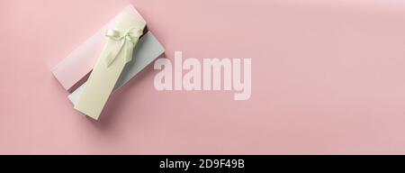Holiday Boxen verschiedenen Pastellfarben mit glänzenden Band rosa Hintergrund Draufsicht Stockfoto