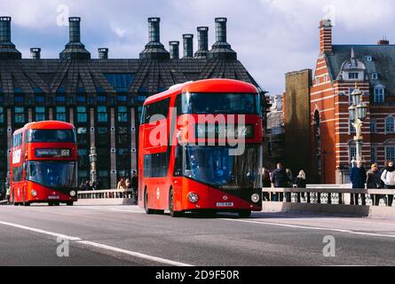 Zwei rote Busse überqueren die Westminser Bridge in London, Großbritannien. Stockfoto