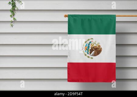 Mexiko National kleine Flagge hängt von einem Pfostenzaun entlang der Holzmauer in einer ländlichen Stadt. Konzept des Unabhängigkeitstages. Stockfoto