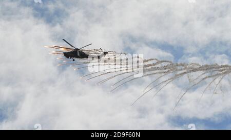 Kubinka, Russland. August 2020. Kampfhubschrauber Mi-28 gibt einen Fan von Hitzefallen frei.Flugschau auf dem Flugplatz Kubinka während des internationalen Forums der Armee-2020 des russischen Verteidigungsministeriums.die Flugschau in Kubinka ist einer der Höhepunkte des Militärforums der Armee 2020. Es findet in der Regel parallel zu den Armeespielen. Im Jahr 2020 führten sie Kunstflug am Himmel durch: Mi-28 Kampfhubschrauber, das Swifts Kunstflugteam auf der MiG-29, die russischen Ritter auf der Su-30SM und Su-35S sowie die einzige Gruppe in Russland auf Sportkolbenflugzeugen "der erste Flug". Eines der Y Stockfoto