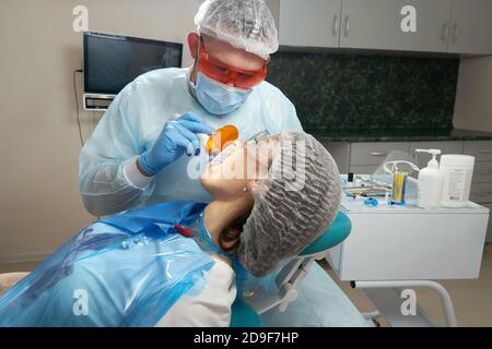 Zahnarzt tun Verfahren mit zahnmedizinischen Härtung mit UV-Licht in der Klinik Stockfoto