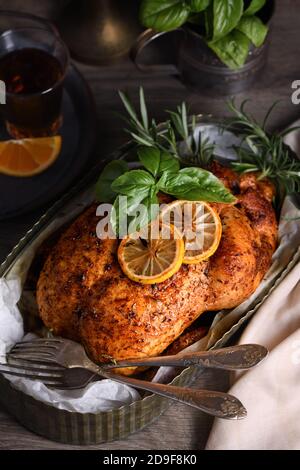 Gebackenes Hähnchen in Gewürzen mit knusprig appetitlich gebratener Kruste in einem Tablett, dunkel launisch Stockfoto