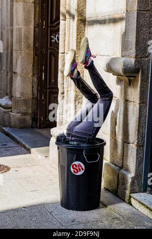Frauenbeine im Abfalleimer Stockfoto