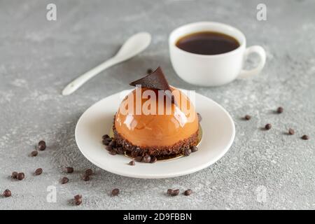 Leckere Schokolade runden Mousse Kuchen und Tasse Kaffee auf Steintisch Stockfoto