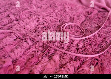 Cyclomen Farbe Textil Hintergrund. Auf der flauschigen leichten Textur sind die genähten Bänder schön in Ton angelegt. Elegante rosa Texturen. Stockfoto