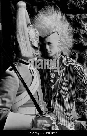 Punk Rocker Matt Belgrano, 'The Postcard Punk' steht mit einem Mitglied der Household Cavalry, Horse Guards Parade, London, England, UK, um 1980 Stockfoto