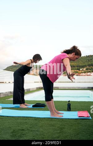 Zwei Frauen üben Yoga auf der Terrasse des Open-Air Haus Stockfoto