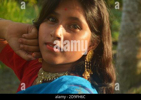 Nahaufnahme eines indischen Teenagers mit Sari, goldener Halskette und Bindi auf der Stirn mit langen dunklen Haaren, selektive Fokussierung Stockfoto