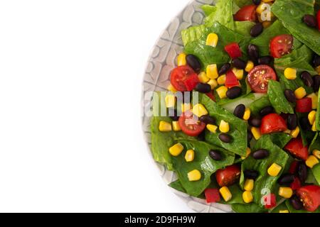 Mexikanischer Salat mit schwarzen Bohnen, Mais, Tomaten, Salat und Pfeffer isoliert auf weißem Hintergrund Stockfoto