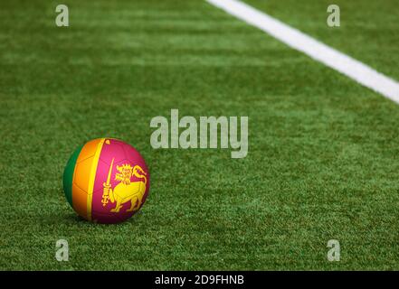 Sri Lanka Flagge auf Ball im Fußballfeld Hintergrund. Fußball-Nationalthema auf grünem Gras. Konzept des Sportwettbewerbs. Stockfoto