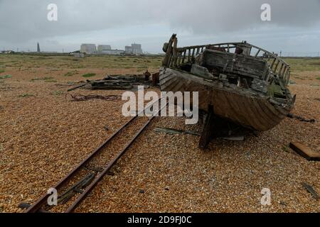 Eine düstere windgepeitschte Szene des Dungeness Beach in Kent, Großbritannien. Alte hölzerne Fischerboot und Windenweg. Stockfoto