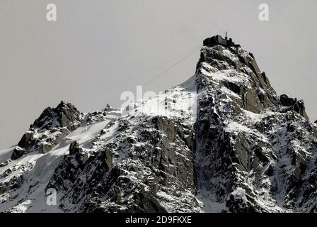 Die höchste vertikale Aufstiegsbahn der Welt benötigt nur 20 Minuten, um den 12,605 m hohen Gipfel der Aiguille du Midi im Mont Blanc-Massiv, Haute-Savoie, Auvergne-Rhône-Alpes, Frankreich, von der Stadt Chamonix aus zu erklimmen und bietet einen herrlichen Blick auf die französischen und italienischen Alpen. Vom Gipfel aus verbindet eine weitere Seilbahn Frankreich und Italien über den Mont-Blanc-Tunnel und die Grenze zum 11,358 m hohen Gipfel Pointe oder Punte Helbronner. Stockfoto