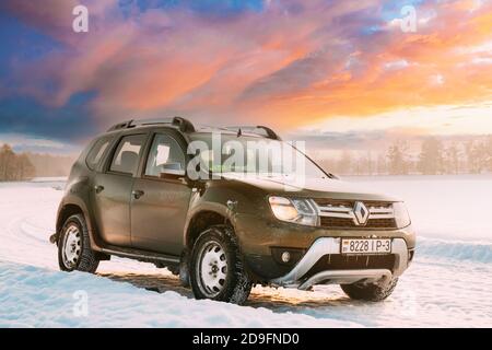 Auto Renault Duster Oder Dacia Duster Suv Geparkt Auf Winter Snowy Feld Bei Sonnenuntergang Dawn Sonnenaufgang. Stockfoto