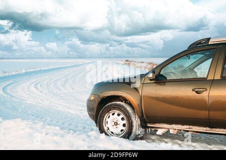 Gefrorene und grungy SUV Auto auf Winter Snowy Field Landschaft geparkt. Veränderter Himmel Stockfoto