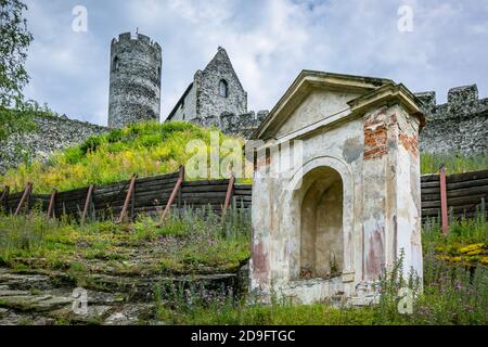 Bezdez, Tschechische Republik - Juli 19 2020: Turm und ein Haus, Teil der mittelalterlichen Burg aus grauen Steinen auf einem Hügel. Sonniger Tag mit blauem Himmel. Stockfoto