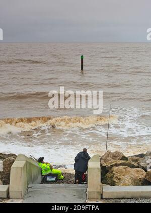 Zwei Angler nehmen einen gemächlichen Ansatz, wenn Seefischen Am Rossall Strand in Fleetwood Stockfoto