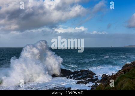 Große Welle bricht auf St Ives Head, aka The Island, St. Ives, Cornwall, Großbritannien Stockfoto