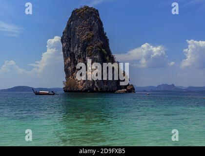 Thailand traditionelle Holz lange Schwanz Boot in türkisblauem Wasser, Inseln Tour, riesige Felsen Hintergrund Stockfoto