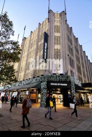 Shopper laufen an der Oxford Street vorbei, dem House of Fraser Store, der alle mit Weihnachtslichtern geschmückt ist.das House of Fraser Kaufhaus in der Oxford Street ist für Weihnachten erleuchtet, obwohl alle nicht unbedingt notwendigen Einzelhandelsgeschäfte nun für die nächsten vier Wochen unter Lockdown geschlossen sind. Stockfoto