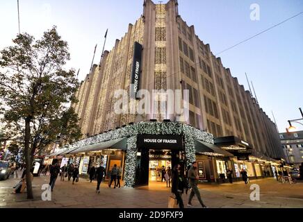 Shopper laufen an der Oxford Street vorbei, dem House of Fraser Store, der alle mit Weihnachtslichtern geschmückt ist.das House of Fraser Kaufhaus in der Oxford Street ist für Weihnachten erleuchtet, obwohl alle nicht unbedingt notwendigen Einzelhandelsgeschäfte nun für die nächsten vier Wochen unter Lockdown geschlossen sind. Stockfoto