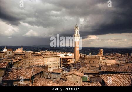 Siena, Piazza del Campo mit dem Torre del Mangia (Pubblico Palast Turm) als Sturmwolken sammeln. Toskana, Italien, Europa Stockfoto