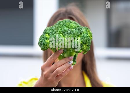 Frau hält Brokkoli in den Händen. Gesunde Pflanze basiert sauber Detox Essen Konzept Stockfoto