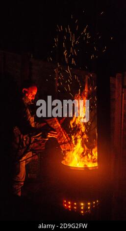 Birmingham, Großbritannien. November 2020. Ein Mann genießt ein Gartenfeuer für Guy Fawkes während des Lockdown. Kredit: Ryan Underwood/Alamy Live Nachrichten Stockfoto