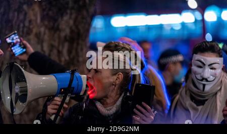 Westminster, London, Großbritannien. November 2020. Am 5. November fand in der Nähe des Parlaments ein regierungsfeindlicher Protest statt, der sich mit dem Schießpulver-Komplott von 1605 und dem Versuch, das Gebäude zu zerstören, verband. Demonstranten tragen oft "V für Vendetta"-Masken mit einer Ähnlichkeit zu Guy Fawkes. Da das Datum auch der erste Tag der nationalen Sperre ist, haben sich Anti-Lockdown-Demonstranten angeschlossen. Eine starke Polizeipräsenz reduzierte die Auswirkungen des Ereignisses, das sich vor dem Trafalgar Square versammelt hatte. Weibliche Gesänge durch Megaphon Stockfoto