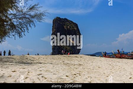 Krabi, Thailand - März 29 2019: Weißer Sand Insel Strand Felsen, traditionelle lange Schwanz Boote Stockfoto