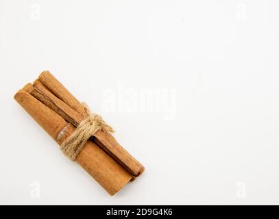 Zimtstangen gebunden mit einer Schnur auf weißem Hintergrund. Stockfoto