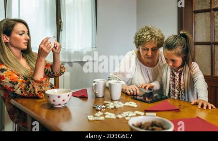 Großmutter und Enkelin spielen ein Spiel auf dem Tablet Stockfoto