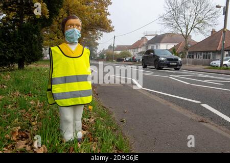 Iver, Buckinghamshire, Großbritannien. November 2020. Ein Fußgänger-Sicherheitsmodell der Kinderschule neben einer Fußgängerüberfahrt trägt eine Gesichtsmaske und einen gut sichtbaren Tabard. Obwohl England in eine Covid-19-Sperre gegangen ist, sind die Schulen noch offen. Alle älteren Kinder und Lehrer in Schulen sind nun verpflichtet, Gesichtsmasken tragen. Quelle: Maureen McLean/Alamy Live News Stockfoto