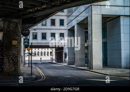 In der Ferne läuft eine Person entlang der Kais in Dublin in der Nähe der Ulster Bank am Georges Quay, mit dem Zollhaus im Hintergrund. Stockfoto