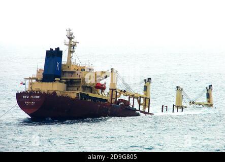 2007 Foto -Wrack des Panama registriert MV NEUE FLAMME liegt halb versenkt vor Europa Point Leuchtturm, Gibraltar -- das panamaische Bulk-Carrier Frachtschiff kollidierte mit dem Heck des Torm Gertrud, ein doppelhulligen dänischen Erdöltanker am 12. August 2007. Sie landete teilweise in der Straße von Gibraltar untergetaucht, brach im Dezember 2007 in zwei Teile und konnte nicht mehr geborgen werden. Die Ladung wurde geborgen und das Heck für Schrott entfernt. Der Hauptmann wurde verhaftet, weil er ohne Erlaubnis abreisen musste. Es wurde im Jahr 1994 gebaut und wurde ursprünglich Skaustrand genannt. Stockfoto