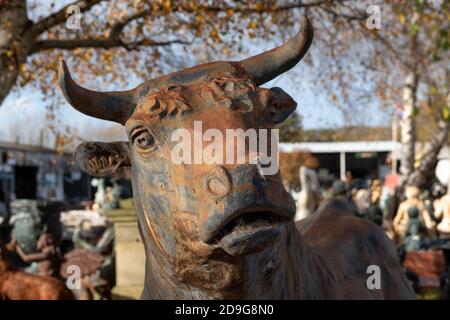 Statueof Stier mit Hörnern inmitten anderer Ephemera auf Rückgewinnungshof in Wells, Somerset UK. Fotografiert Im November 2020. Stockfoto