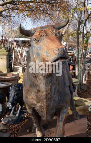 Statueof Stier mit Hörnern inmitten anderer Ephemera auf Rückgewinnungshof in Wells, Somerset UK. Fotografiert Im November 2020. Stockfoto