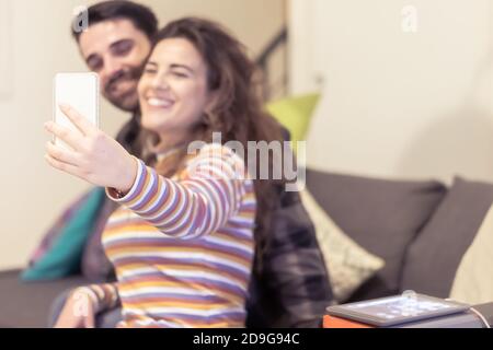 Helle Momente festhalten. Fröhliche junge liebevolle Paar macht Selfie vor der Kamera. Neue Technologietrends und Freundschaftskonzept. Stockfoto