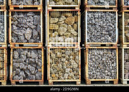 Natursteine in Metallgitter Transportboxen Stockfoto