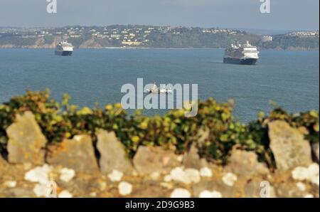 Zwei Kreuzfahrtschiffe der Holland America Line ankerten während der Coronavirus-Pandemie in Tor Bay und schauten von Berry Head nach Torquay. Stockfoto