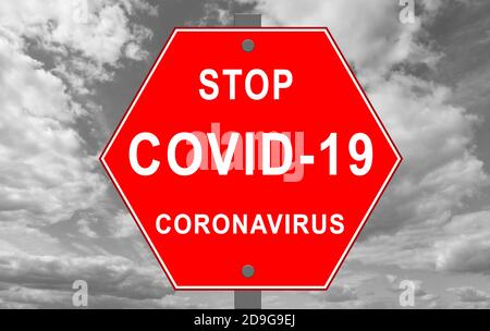 Schild STOP mit den Worten coronavirus und covid-19 auf Himmel Hintergrund Stockfoto