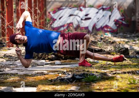 Handsome man Keeping Balance on Hands in Warehouse - muskulös Athletic Bodybuilder Fitness-Modell tun Handstand Push-up Stockfoto