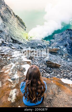 Ein Reisender, der die dampfenden Schwefelminen von Kawah Ijen, Java, Indonesien, betrachtet Stockfoto