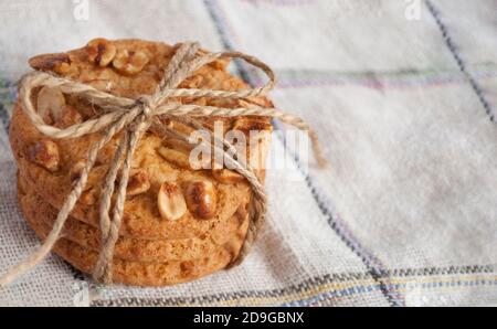 Stapel von Keksen mit Erdnüssen, in Leinenfaden eingewickelt, ein Geschenk Stockfoto